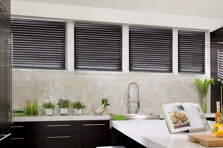 Choose custom Polywood faux wood blinds for your kitchen in Fort Myers. Special shaped faux wood blinds in several windows above a sink.